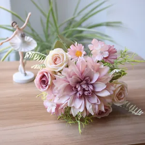 Close-up of artificial bridal bouquet with pink dahlia and roses on a wooden table
