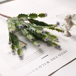 Macro view of artificial succulent branch with purple flowers and green jagged leaves