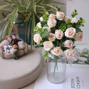 Elegant artificial pink rose bouquet with eucalyptus leaves in glass vase for home decor