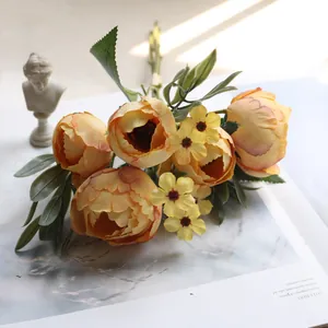 Nahaufnahme eines gelben Seiden-Ranunkel-Bouquets mit Gänseblümchen für die Deko