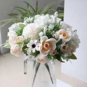Elegant artificial bouquet with white tea buds and daisies in a glass vase