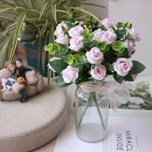 Detailed view of elegant pink artificial rose bouquet with eucalyptus leaves in glass vase