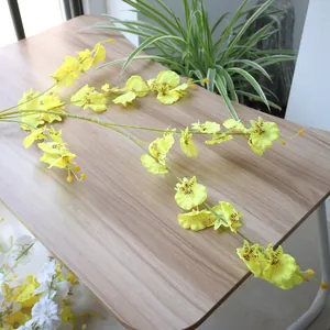 Detailed view of yellow dancing lady orchids with realistic silk textures on wood