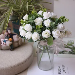 Elegant artificial white rose bouquet with eucalyptus in clear glass vase detail view
