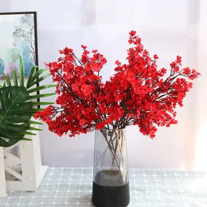 Vista detallada de ramas de flores artificiales de paniculata de seda roja en un jarrón