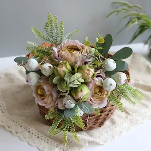 Close-up detail of vintage pink artificial peony bouquet arranged in a rustic woven basket