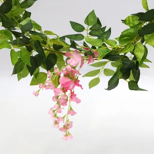 Detailopname van kunstmatige blauweregenrank met roze bloemen en groene bladeren