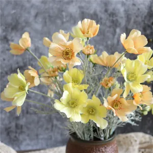 Dettaglio di fiori di cosmo artificiali realistici in morbide tonalità giallo e arancio
