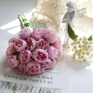 Close-up of elegant 27-head pink artificial tea rose bouquet on an open magazine page