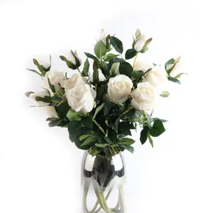 Gros plan détaillé de roses artificielles blanches dans un vase en verre argenté chic