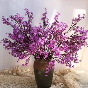 Vista detallada de flores de seda artificiales moradas en un jarrón de cerámica