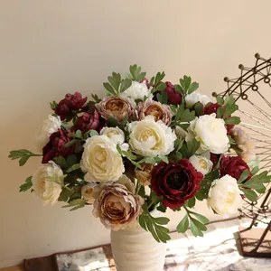 Macro detail of 2-headed artificial silk peony flowers in a cream white ceramic vase