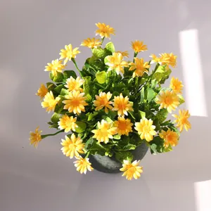 Top view of vibrant yellow artificial chamomile daisies in a rustic textured green pot