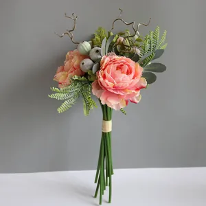 Detailed shot of a realistic pink artificial peony bouquet with mixed greenery.