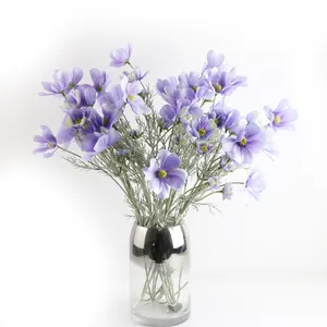 Eleganti fiori di cosmo viola artificiali in un vaso di vetro sfumato argento per la tavola