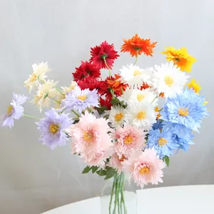 Close-up of multi-colored artificial chrysanthemum flowers in a clear glass vase