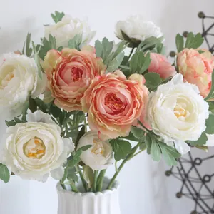 Close-up of realistic artificial silk ranunculus flowers in soft peach and white