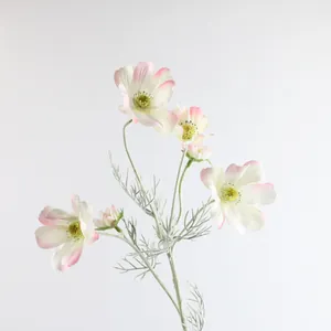Primo piano di fiori di cosmo artificiali con petali di seta bianca e bordi rosa