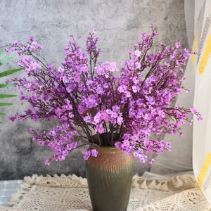 Nahaufnahme von lebensechten künstlichen lila Schleierkrautblüten in einer Keramikvase