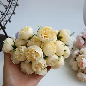 Detail shot of a 27-head champagne tea rose artificial bouquet held in hand for scale
