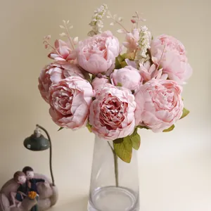 Nahaufnahme von 13-köpfigen rosa künstlichen Pfingstrosen in einer Glasvase.