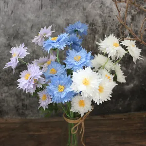 Detailed close-up view of five-headed artificial chrysanthemum flowers in a rustic glass vase.
