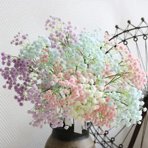 Close-up view of colorful artificial gypsophila flowers in a rustic ceramic vase
