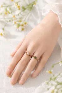 Detailansicht von handgefertigten Natursteinringen am Finger einer asiatischen Frau.