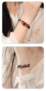 Elegante primo piano di bracciali a due fili in perle di granato naturale con perle e charms