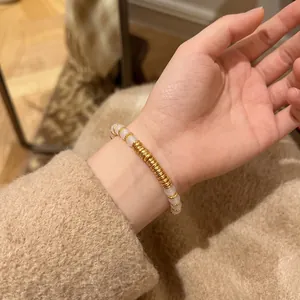 Gros plan d'un bracelet en agate naturelle avec des perles dorées sur un poignet