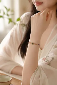 Bracelet élégant en pierres naturelles et perles de cristal améthyste au poignet d'une femme.