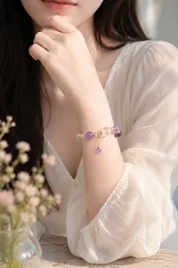 Elegante Detailansicht eines Armbands aus Amethyst- und weißen Kristallperlen am Handgelenk