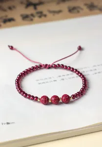 Dettaglio macro di un bracciale in granato rosso e cinabro intagliato in stile cinese