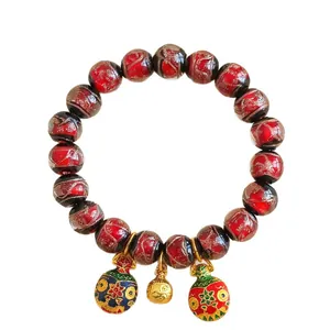 Bracelet traditionnel en perles de verre rouge marbré avec breloques émaillées colorées