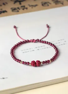 Primo piano di un bracciale di granato naturale con perle di cinabro intagliate
