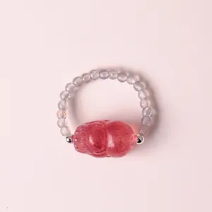Nahaufnahme eines Perlenrings aus Naturkristall mit geschnitztem rosa Turmalin.