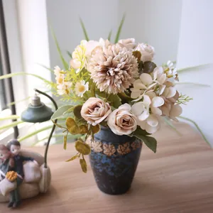 Detailansicht eines künstlichen Herbststraußes mit Rosen und Chrysanthemen in einer Vase.