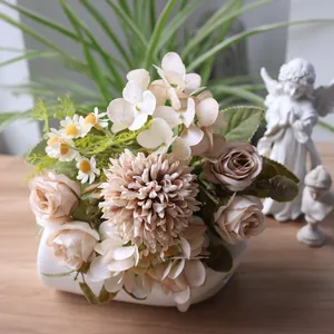 Nahaufnahme eines herbstlichen Kunstblumenstraußes mit Rosen und Hortensien in einer Vase