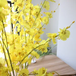 Close-up view of bright yellow silk Dancing Orchid petals with dark brown spots.