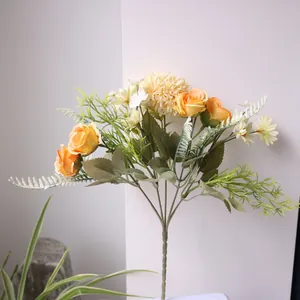 Detailweergave van kunstbloemboeket met gele rozen, pompons en witte madeliefjes