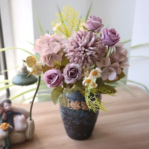 Nahaufnahme von künstlichen Herbstblumen in einer dunkelblauen Vase