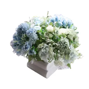 Bouquet de roses bleues artificielles avec alliums dans un vase blanc pour mariage.