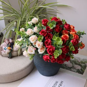 Detail of vibrant artificial rose bouquet with eucalyptus leaves in a rustic blue pot