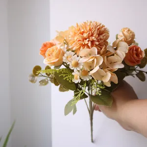 Handgehaltener herbstlicher Seidenblumenstrauß mit Rosen, Chrysanthemen und Hortensien