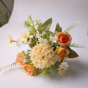 Detail van een kunstboeket met oranje rozen, pompon chrysanten en witte madeliefjes