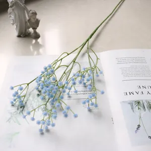 Detailansicht eines einzelnen blauen künstlichen Schleierkrauts auf offenem Buch