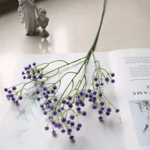 Detailansicht eines lila künstlichen Schleierkraut-Zweiges auf einer offenen Magazinseite.