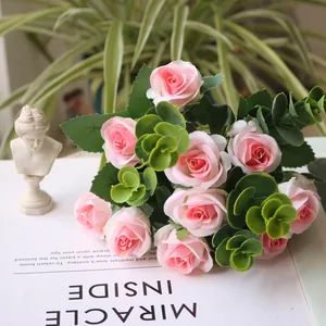 Close-up of artificial pink rose bouquet with eucalyptus leaves on a book
