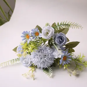 Detail van kunstbloemboeket met blauwe distelbollen rozen en madeliefjes decoratie