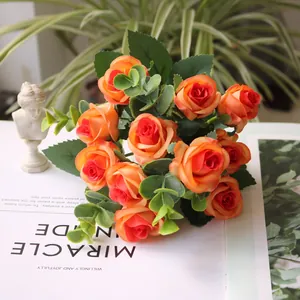 Close-up of vibrant artificial orange roses with eucalyptus leaves for elegant home decoration